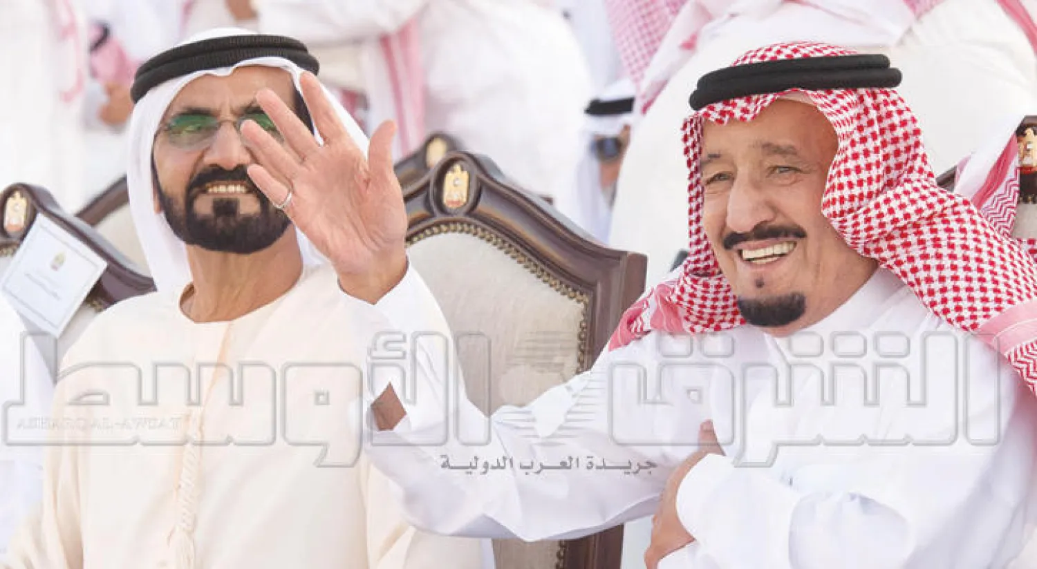 الملك سلمان مشاركاً بيده في فقرة العرضة التي أديت أمامه فيما حاكم دبي يتابع مبتسماً