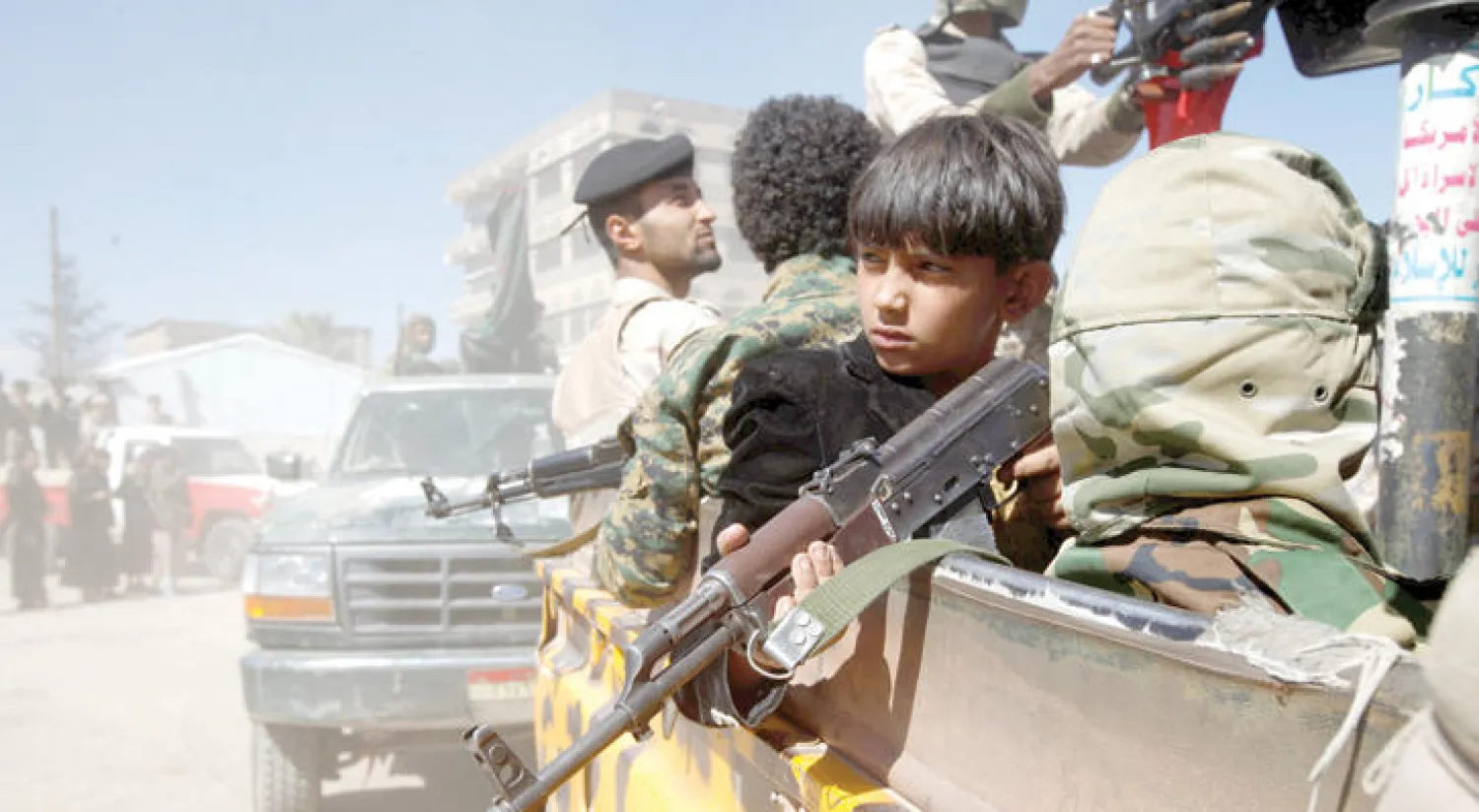 أطفال يحملون سلاحا في سيارات تنقل موالين للحوثي وصالح في صنعاء (رويترز)