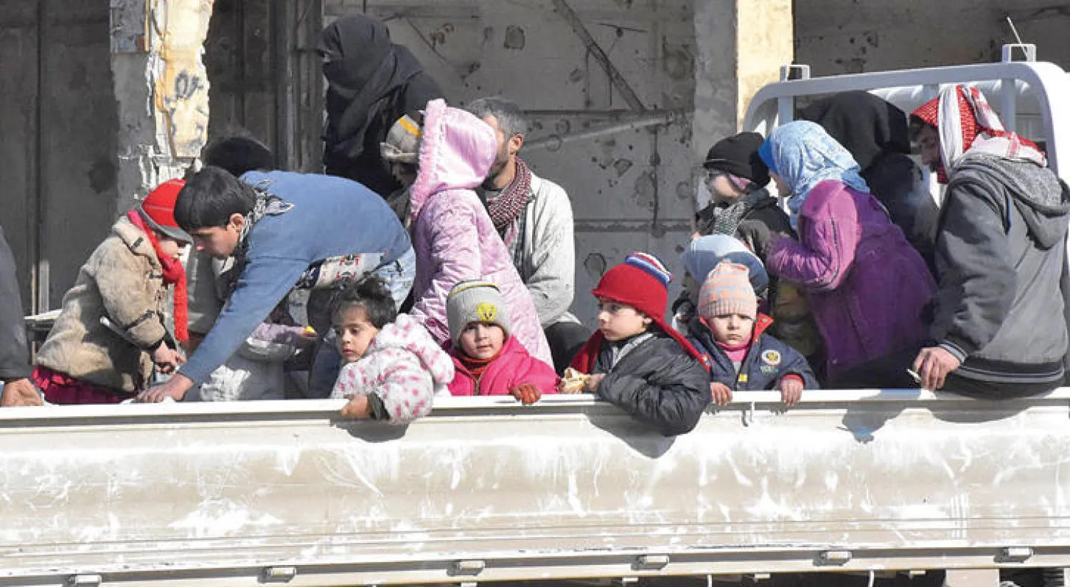 عائلات سورية تنتظر في حي باب الحديد بحلب للعودة إلى مناطق سكنها في السابق أمس (أ.ف.ب)