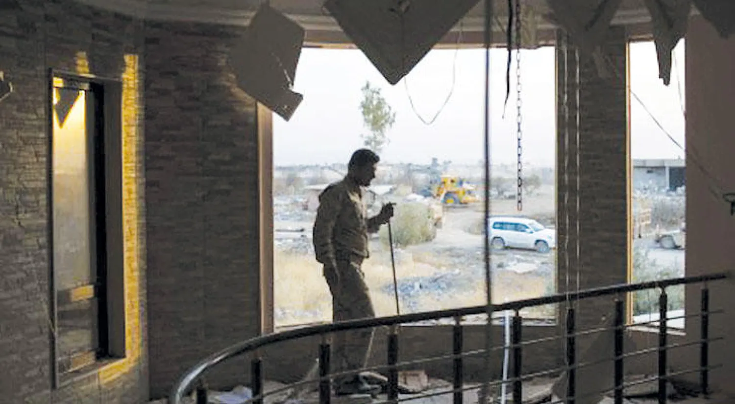 عنصر من البيشمركة يعاين الدمار الذي خلفته «داعش» في منزل ببعشيقة (أ.ب)