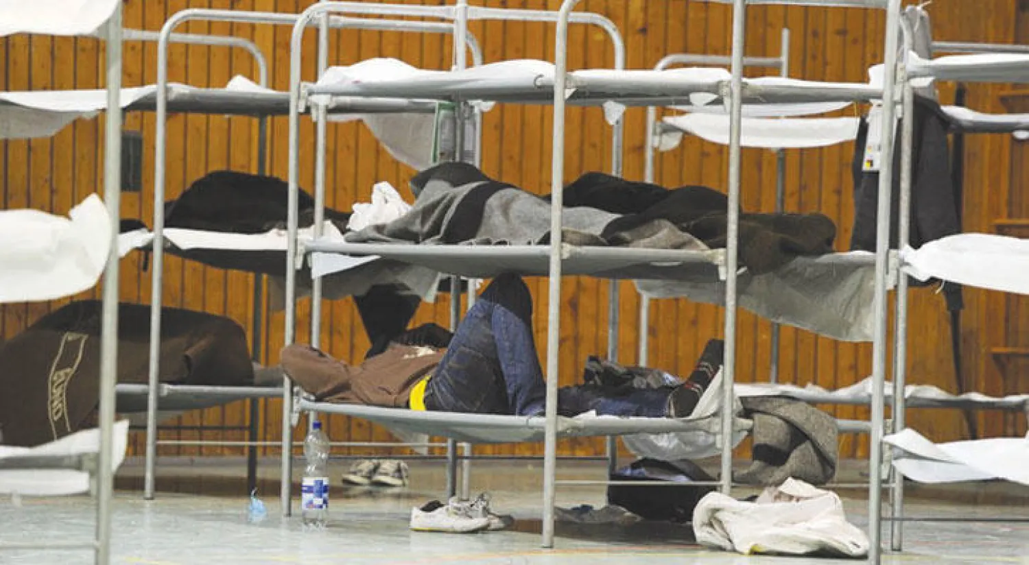 يجري حشر اللاجئين الجدد في قاعات الرياضة والخيام بل وأحيانا في العراء رغم وجود أكثر من 2500 مكان شاغر في بيوت اللاجئين الرسمية (إ.ب.أ)