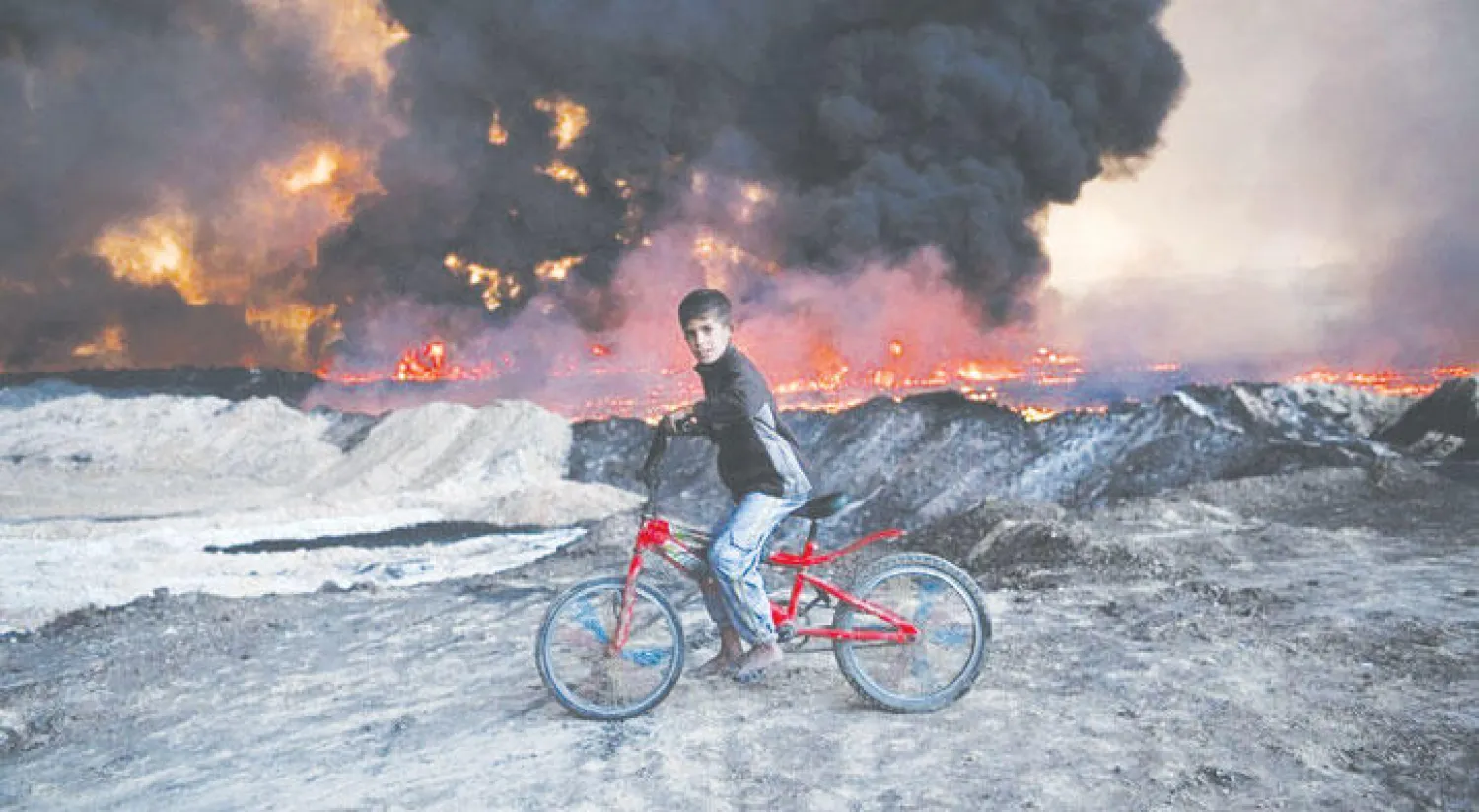 صبي عراقي يفر من حرائق «داعش» في الموصل (واشنطن بوست)