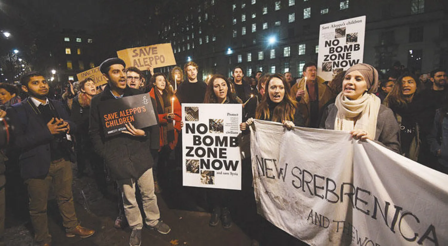 متظاهرون أمام مقر رئيسة الحكومة البريطانية، أمس، يطالبون بوقف الغارات على حلب، ضمن تحرك شعبي في أكثر من مكان في العالم أمس (إ.ب.أ)