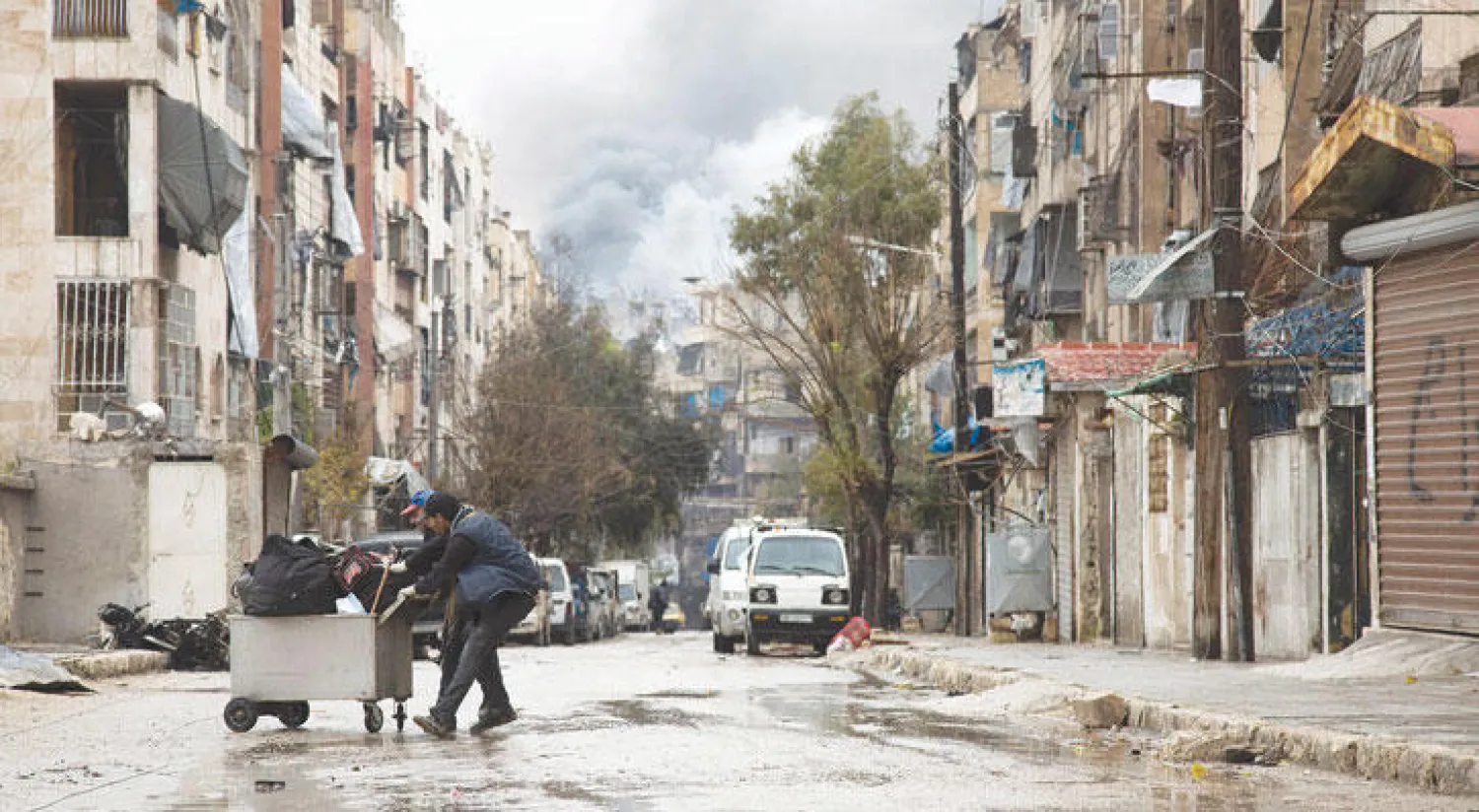 دخان المعارك في حلب يبدو في خلفية حي الشعار الذي سيطرت عليه قوات النظام وحلفائه مؤخرًا في حين يسعى بعض السكان للخروج إلى مناطق أكثر أمانًا (أ.ف.ب)