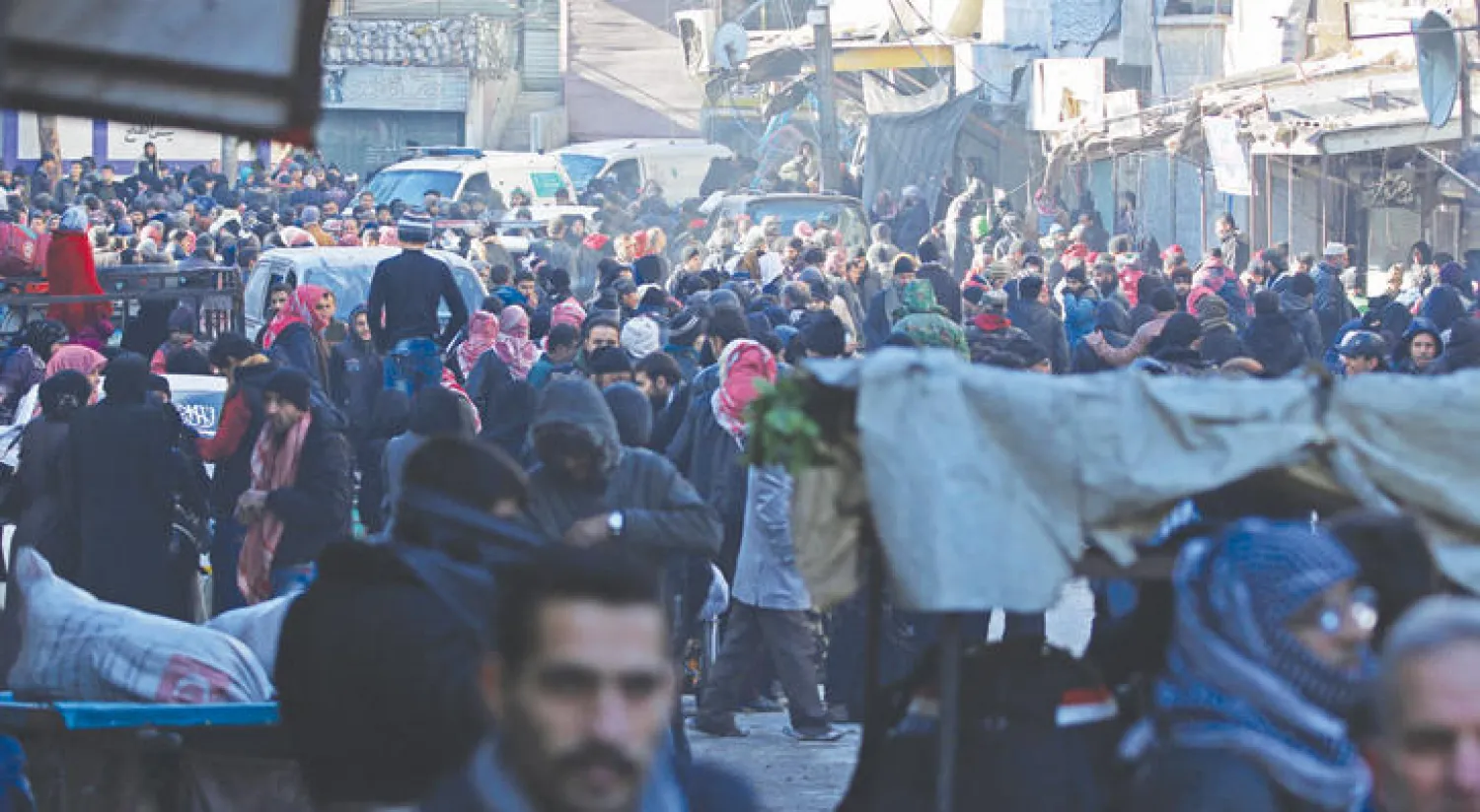 تجمع المدنيين في حي السكري في حلب أمس استعدادا للإجلاء إلى خارج المدينة (رويترز)