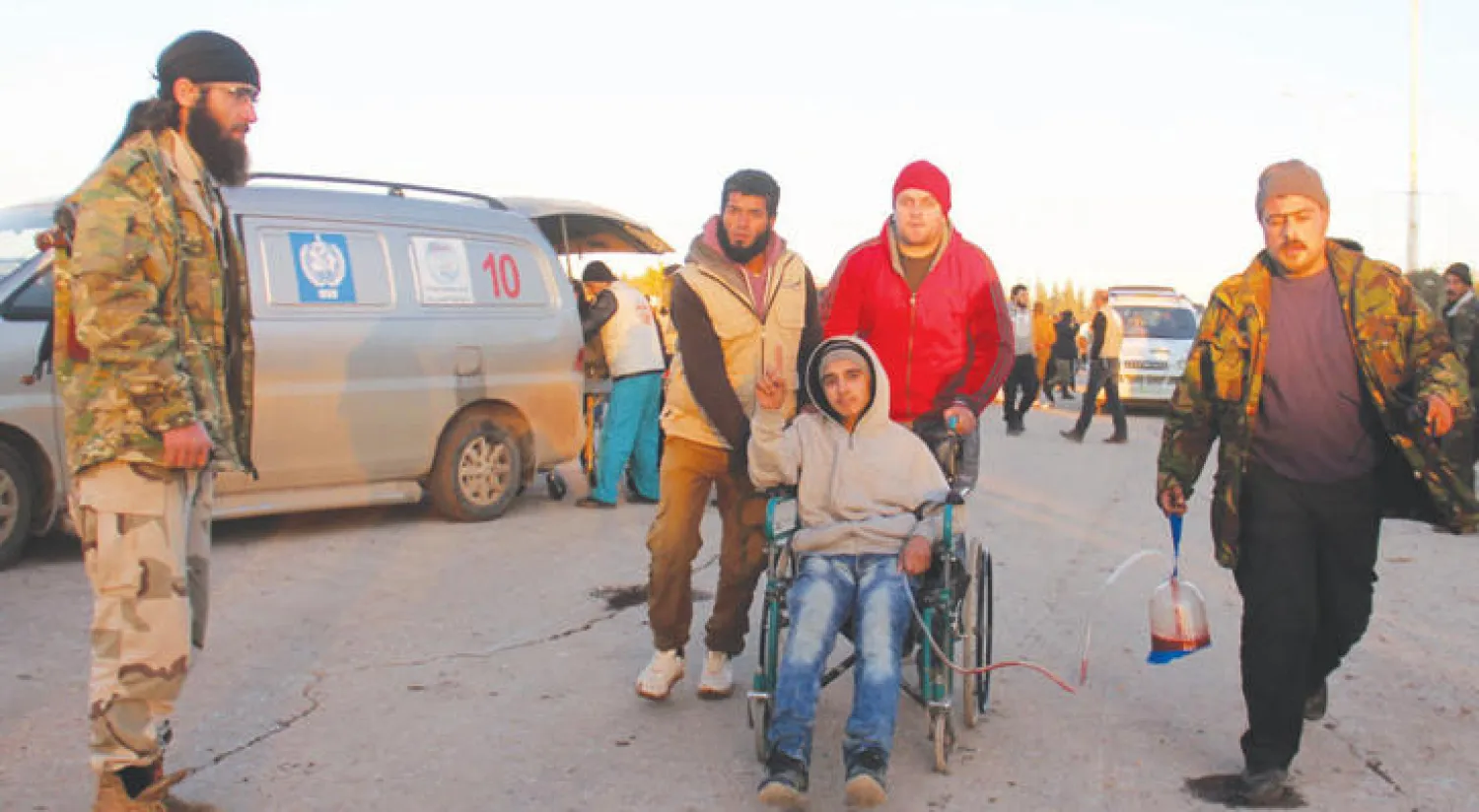 شاب جريح ممن تم اجلاؤهم، امس، تم استقباله من قبل موظفي إغاثة، لدى وصوله إلى خان العسل، بريف حلب (إ ف ب)