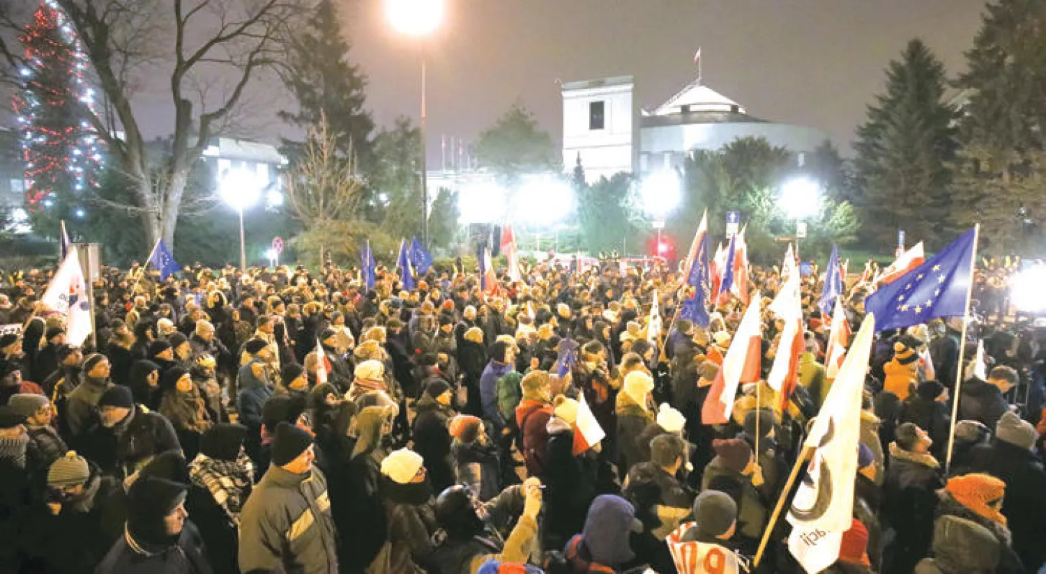 بولنديون يتظاهرون أمام مبنى البرلمان بعد أن أغلقوا مداخله أمس (إ.ب.أ)