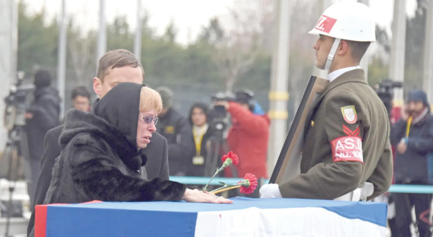 مارينا كارلوف زوجة السفير الروسي آندريه كارلوف الذي اغتيل الاثنين الماضي في أنقرة ترافقه إلى المطار قبل نقل جثمانه إلى روسيا أمس (إ.ب.أ)