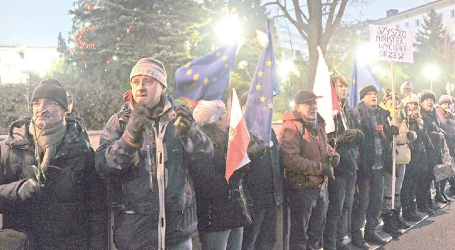 متظاهرون بولنديون يقفون خارج البرلمان في وارسو أمس (أ.ب)