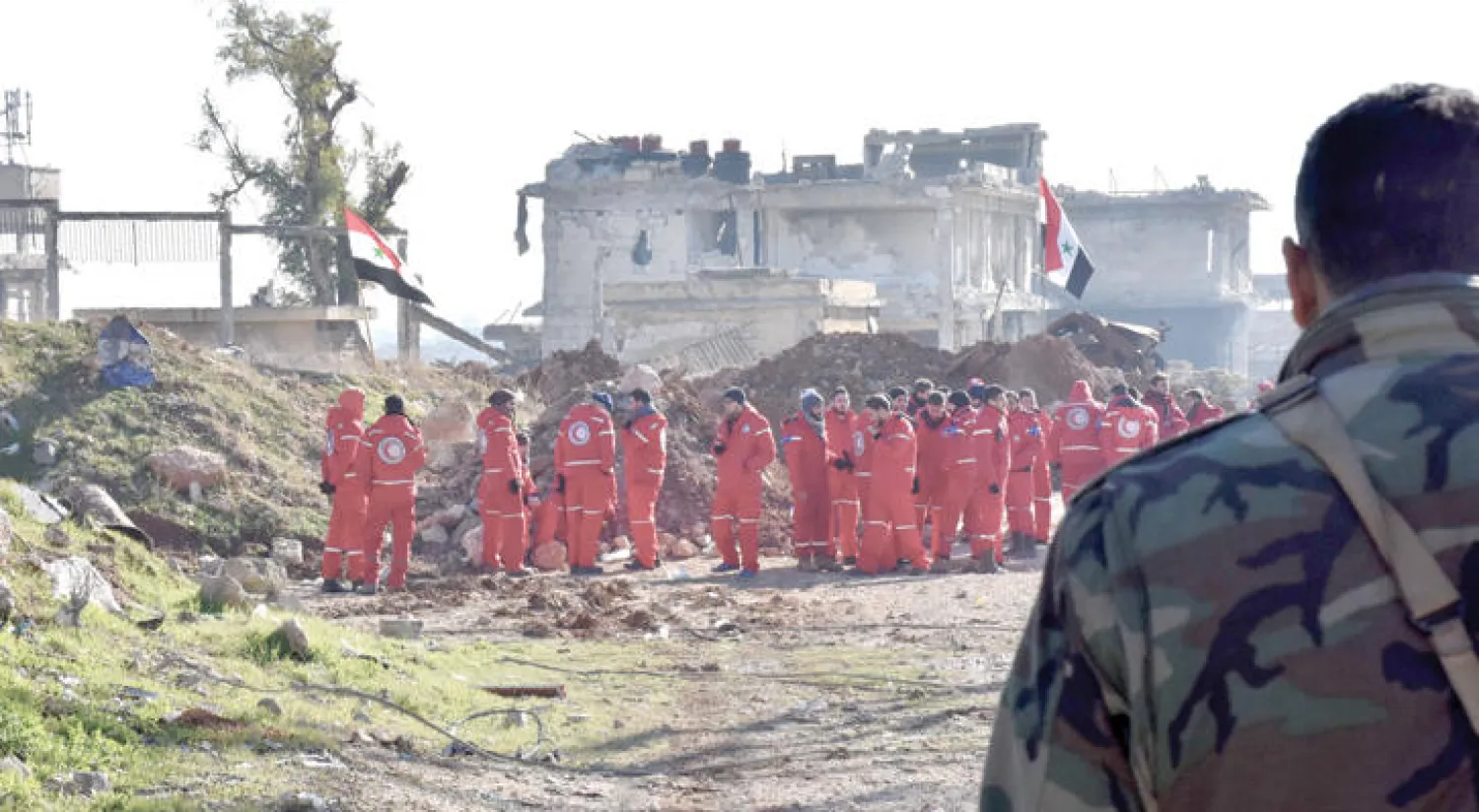 قوات النظام السوري والهلال الأحمر السوري قرب الراموسة استعدادًا لإجلاء المدنيين من شرق حلب، أمس (أ.ف.ب)