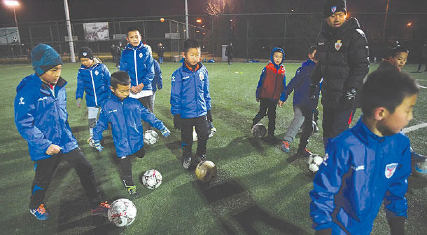 أطفال صينيون يتدربون في نادٍ لكرة القدم في العاصمة بكين (أ.ف.ب)