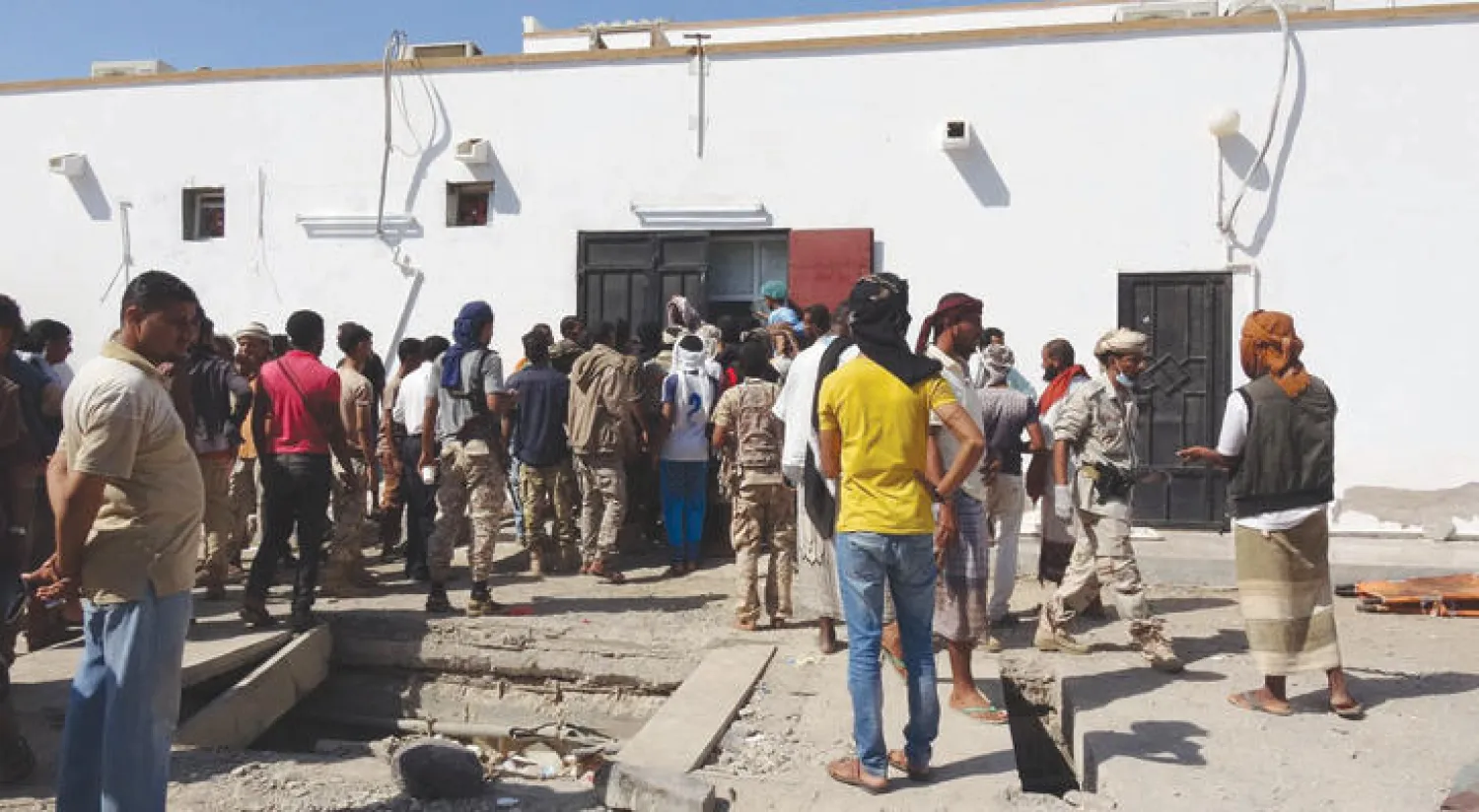 يمنيون أمام مستشفى نقل إليه جنود أصيبوا بتفجير قرب معسكر الصولبان شرق عدن يوم 18 ديسمبر الحالي (رويترز)