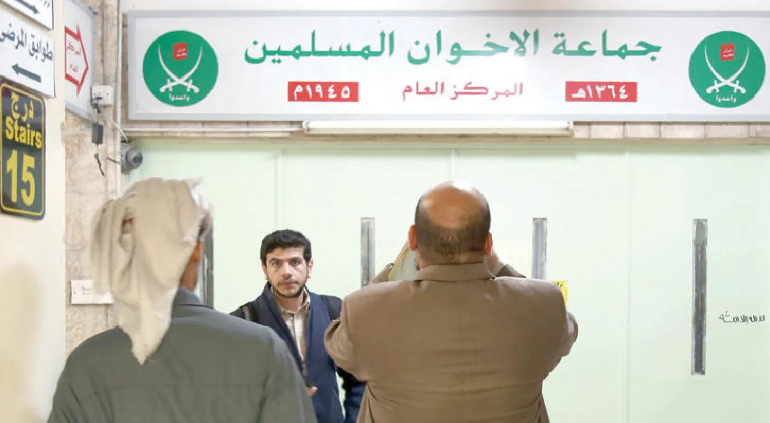 مواطنون أردنيون أمام مدخل مقر جماعة الإخوان المسلمين في العاصمة الأردنية عمّان بعدما أغلقته السلطات الحكومية خلال أبريل  الماضي  (آ ف ب)