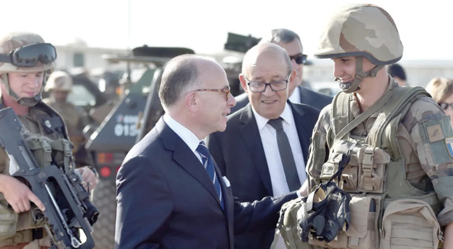 رئيس وزراء فرنسا برنار كازنوف ووزير الدفاع جون إيف لودريان يتحدثان إلى أحد الجنود الفرنسيين المرابطين في تشاد أمس (رويترز)