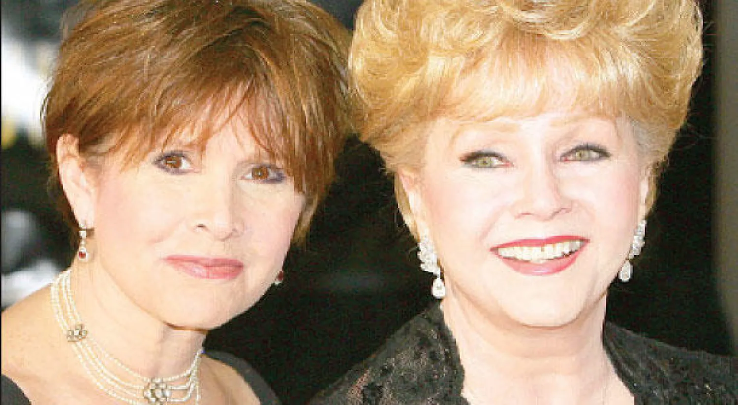 ديبي رينولدز مع ابنتها كاري فيشر في صورة تعود لـ27 فبراير 2007 لحضور عيد ميلاد إليزابيث تايلور الخامس والسبعين. (أ.ف.ب)