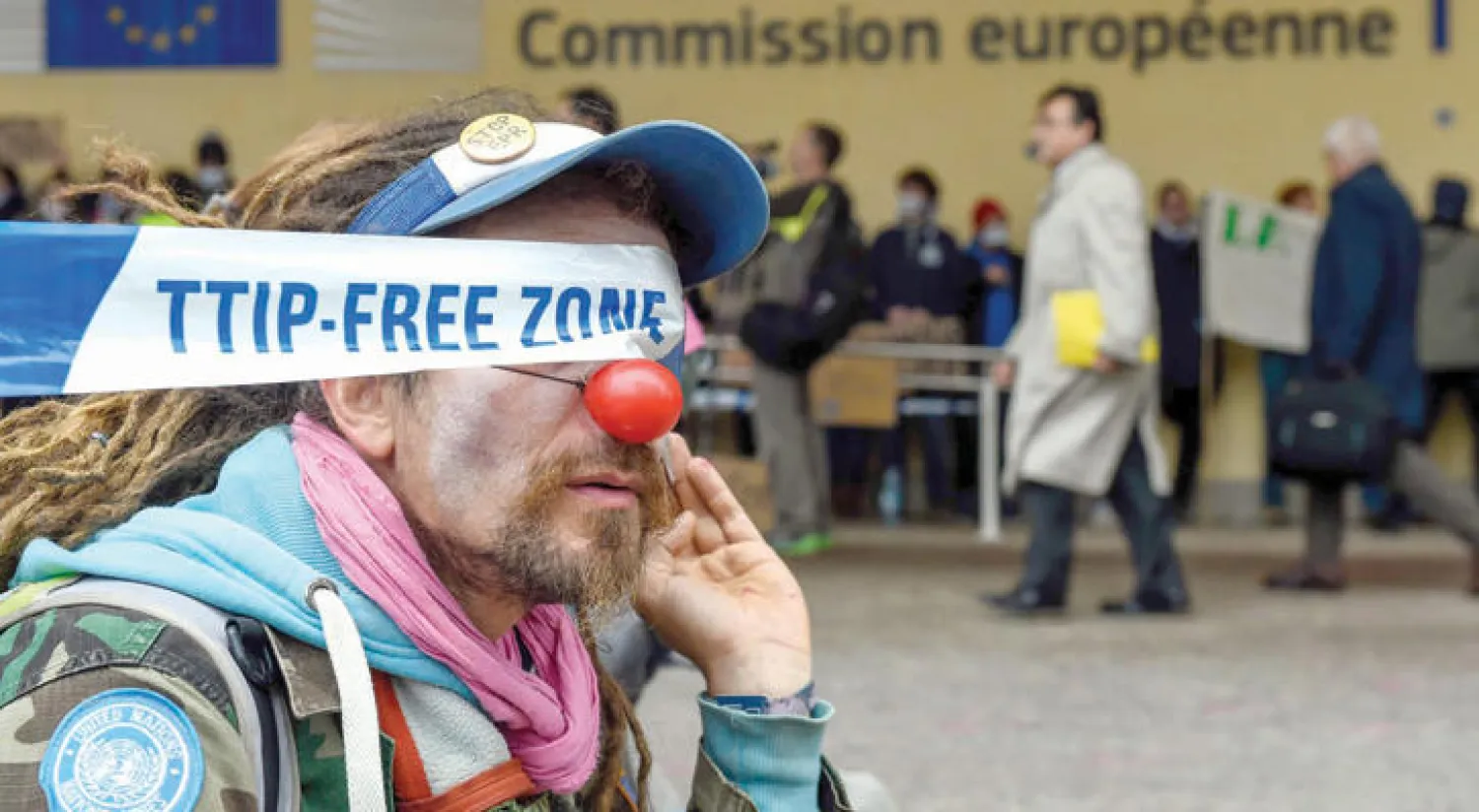 مواطن بلجيكي يرتدي زي مهرج في أكتوبر الماضي في العاصمة البلجيكية بروكسل وسط احتجاجات جرت هناك على اتفاقية التجارة الحرة بين الاتحاد الأوروبي وكندا (أ.ف.ب)