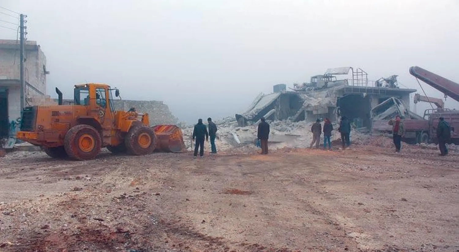 سكان من بلدة الأتارب بريف حلب الغربي يتفقدون الدمار الذي ألحقه طيران الأسد بالمنطقة في أعقاب إلقاء قنابل فراغية أمس (غيتي)