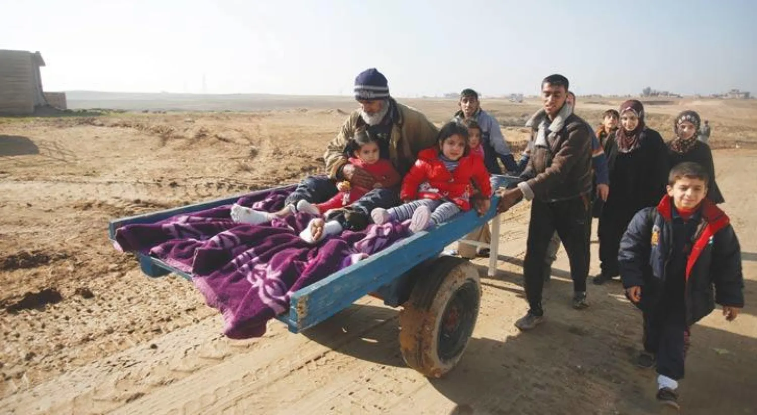 مدنيون هاربون من جحيم معارك الموصل في طريقهم إلى منطقة آمنة بالجانب الأيسر من الموصل أمس (رويترز)