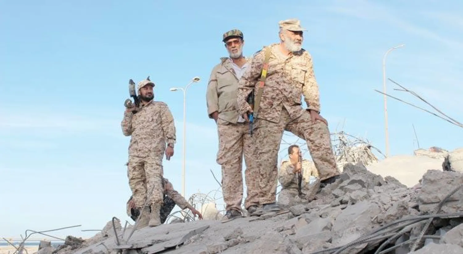 جنود ليبيون يقفون فوق أنقاض بناية مهدمة بعد استرجاع مدينة سرت من تنظيم «داعش» الإرهابي الشهر الماضي (رويترز)