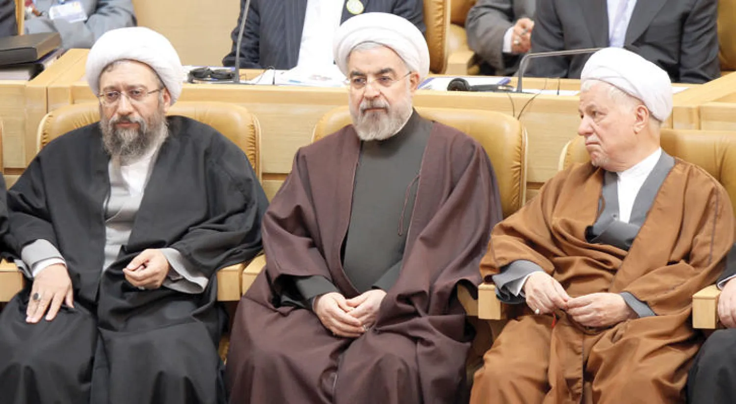 الرئيس الإيراني حسن روحاني يتوسط الرئيس السابق لإيران أكبر هاشمي رفسنجاني (يمين) ورئيس القضاء صادق لاريجاني خلال حضورهم الدورة التاسعة للمؤتمر البرلماني لمنظمة التعاون الإسلامي (غيتي)