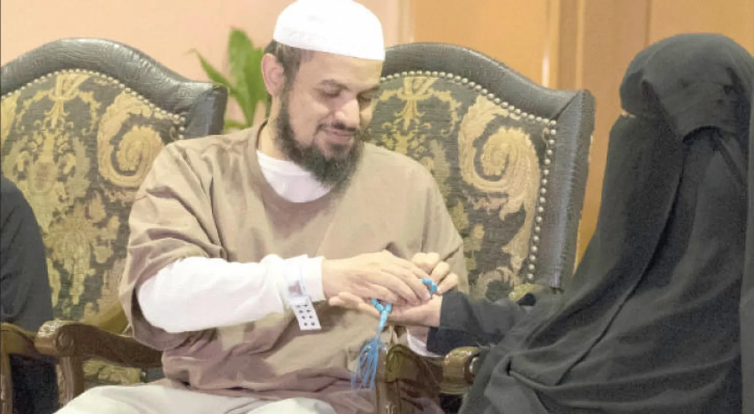 المفرج عنه عبد الله الشلبي لدى إهدائه والدته «مسبحة» بعدما قبّل قدميها بمطار الرياض أمس (تصوير: علي العريفي)