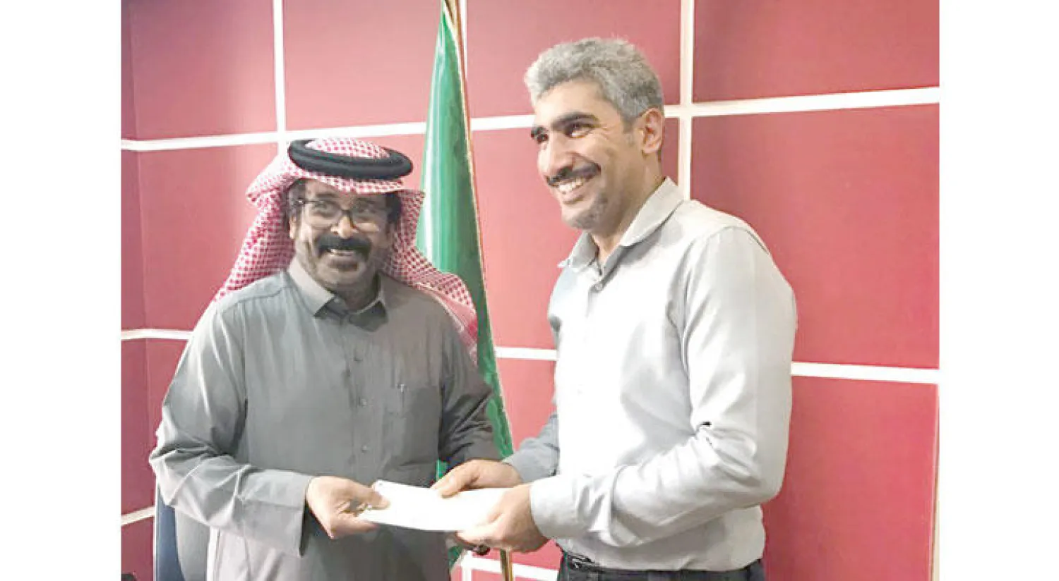 أحد أصحاب العقارات في حي المسوّرة ببلدة العوامية يتسلم شيك التثمين («الشرق الأوسط»)