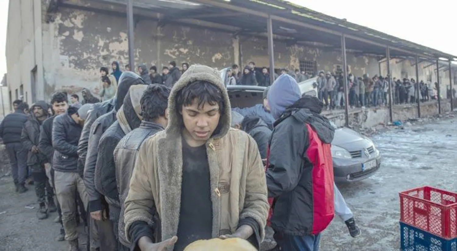 لاجئون يصطفون لتسلم المعونات الغذائية في صربيا (غيتي)