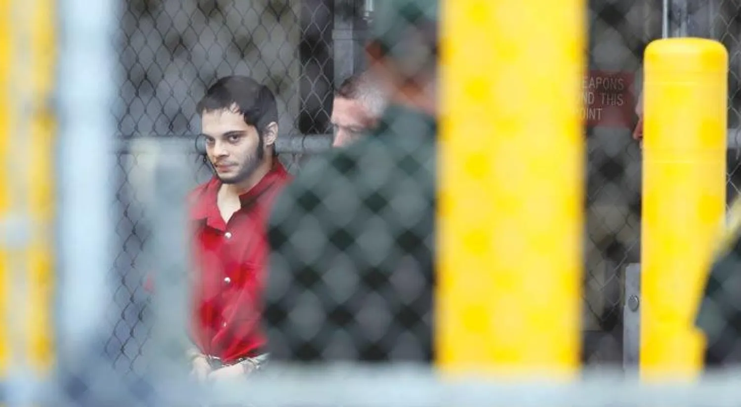 استيبان سانتياغو منفذ الهجوم على مطار لودرديل الذي أسفر عن مقتل 5 مسافرين وإصابة 8 في طريقه إلى قاعة المحكمة الفيدرالية أمس (أ.ب)