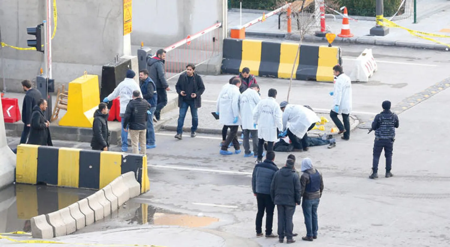 محققون يعاينون جثة مسلح قتل خلال إطلاقه النار أمام مركز للشرطة في مدينة غازي عنتاب جنوب تركيا أمس (إ.ب.أ)