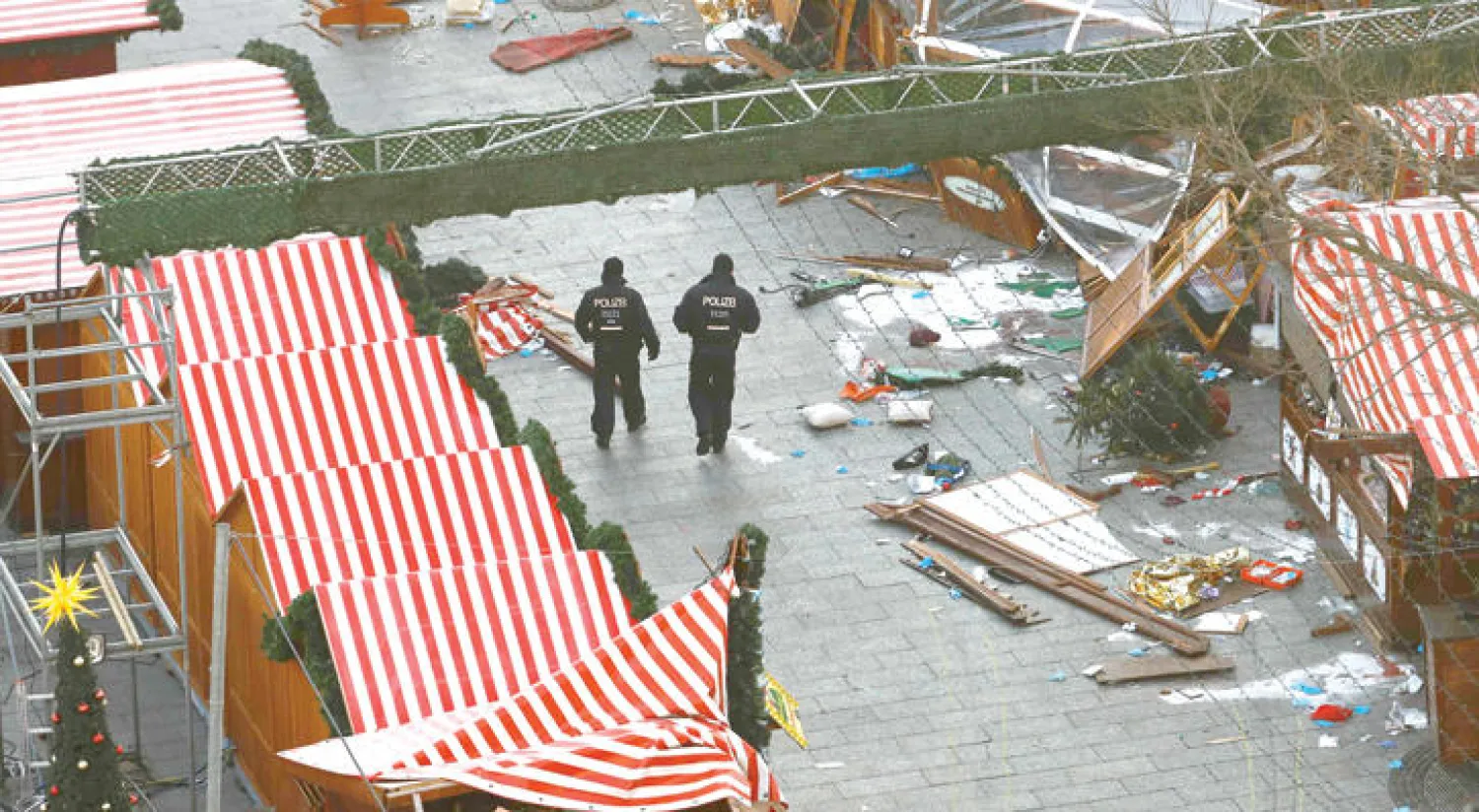 رجال شرطة يتفحصون آثار الدمار الذي خلفه الحادث الإرهابي الذي ضرب سوقا لأعياد الميلاد في برلين في ديسمبر الماضي (أ.ف.ب)