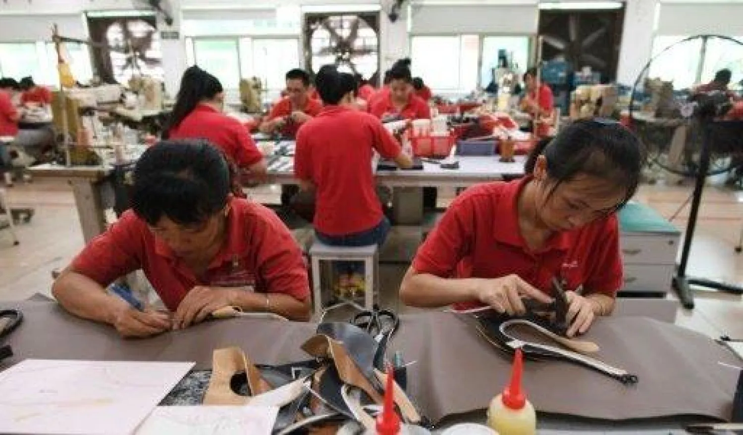 عمال في مصنع للأحذية في دونغ غوان في اقليم غواندونغ الجنوبي الصيني 14 سبتمبر 2016 (أ.ف.ب)