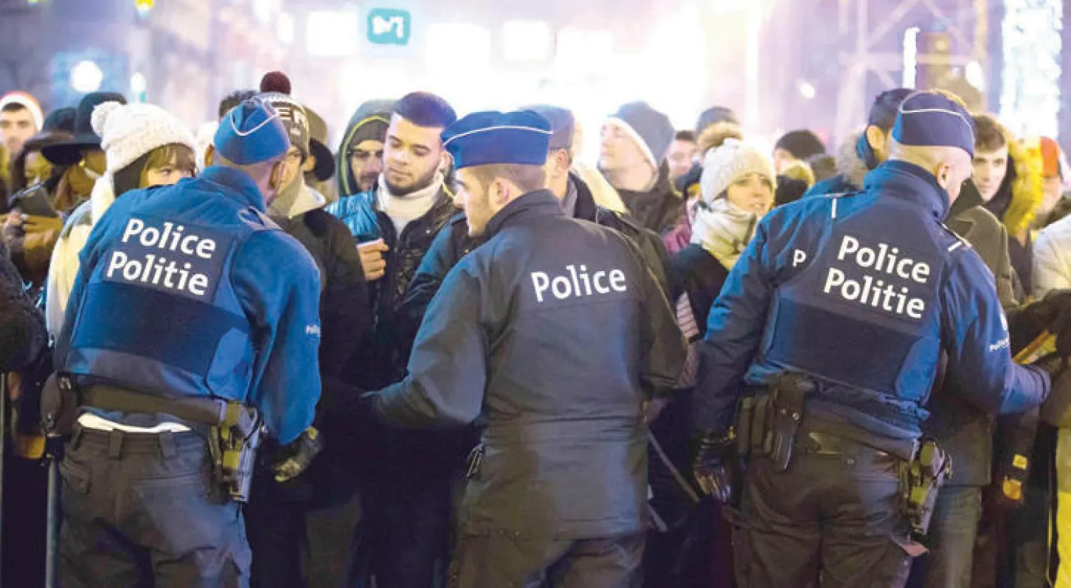 ضباط الشرطة البلجيكية يفتشون مواطنين شاركوا في احتفالات العام الجديد وسط إجراءات أمنية مشددة خوفًا من وقوع عمليات إرهابية في بروكسل (إ.ب.أ)