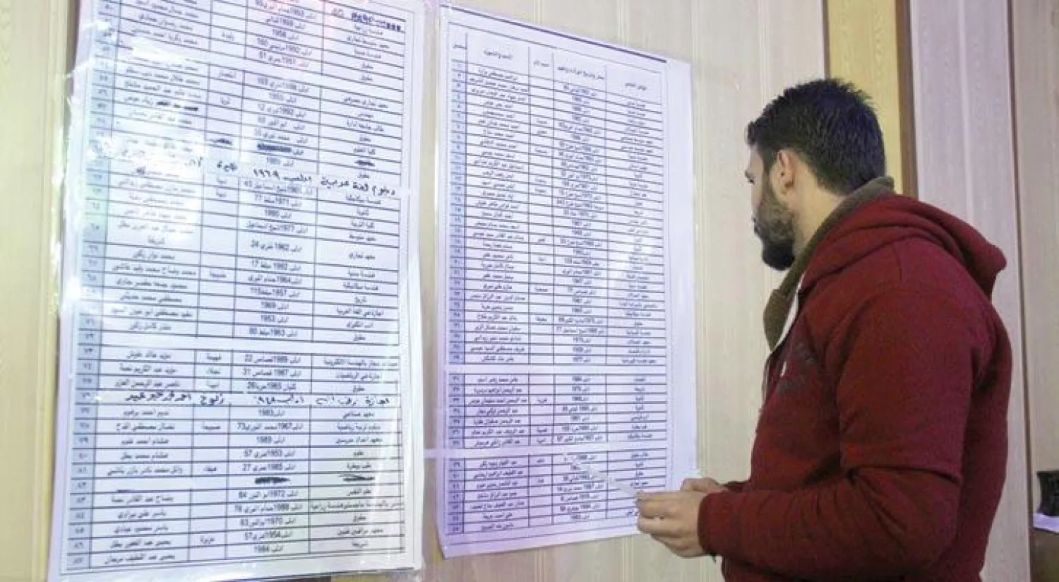 أحد سكان إدلب شمال سوريا يتفحص، أمس، داخل مركز اقتراع، قائمة الناخبين الذين يحق لهم المشاركة في أول انتخابات لمجلس محلي للمدينة (أ.ف.ب)