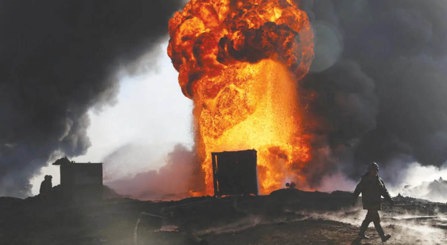 نيران اشعلها مسلحو «داعش»  بآبار النفط قبل فرارهم من القيارة (رويترز)