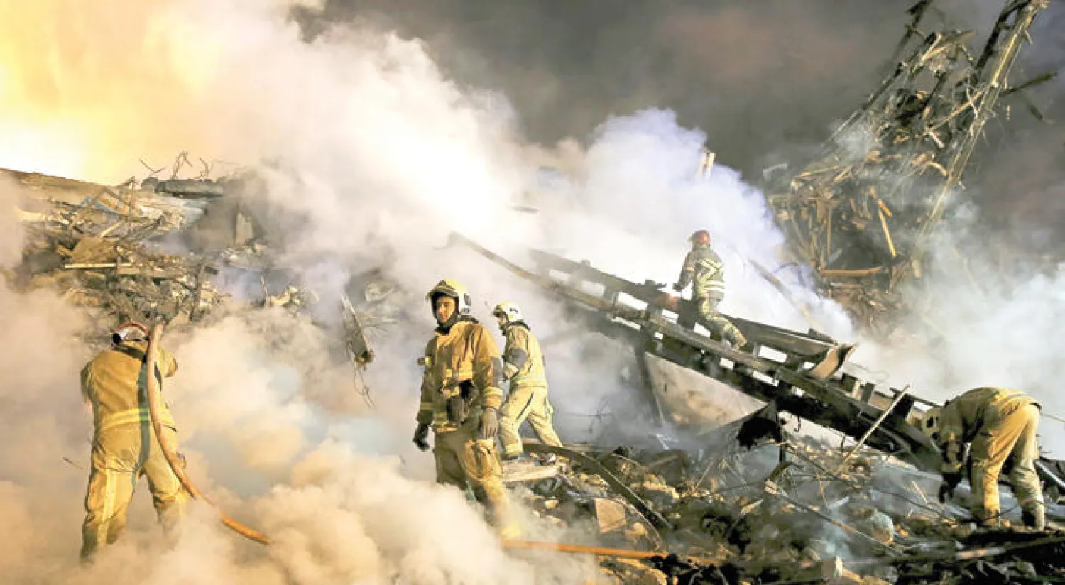 فرق الإنقاذ الإيرانية تواصل عملية البحث عن ناجين أمس وسط تصاعد الدخان من مجمع «بلاسكو» التجاري في اليوم الثالث على انهياره (أ.ب)