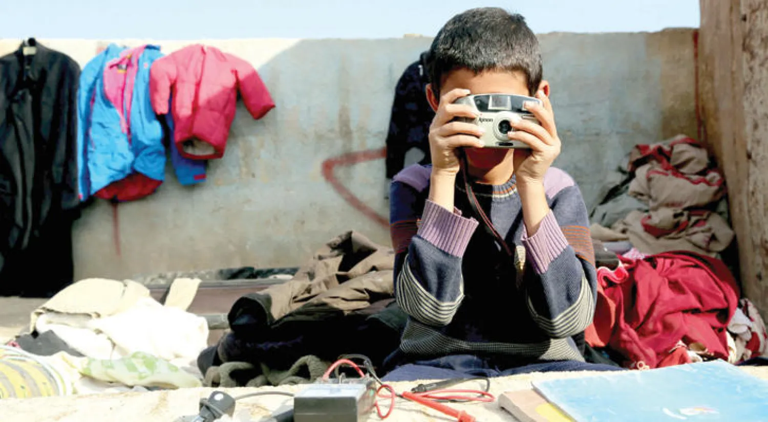 طفل سوري في أحد المباني المهدمة بالقامشلي  (أ.ف.ب)