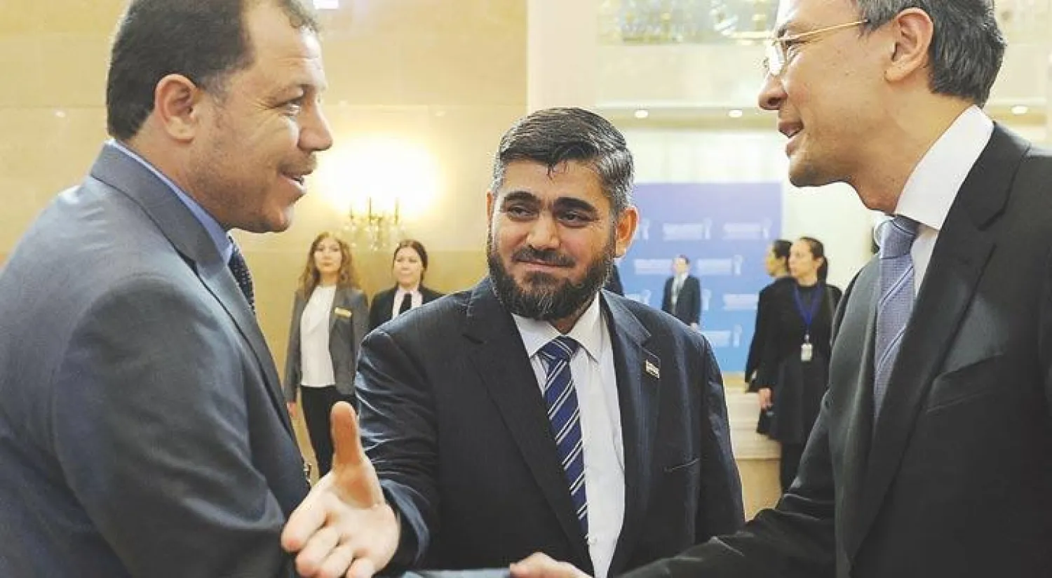 كبير مفاوضي المعارضة السورية محمد علوش (وسط) لدى وصوله إلى مقر المؤتمر في العاصمة الكازاخية آستانة أمس (أ.ف.ب)