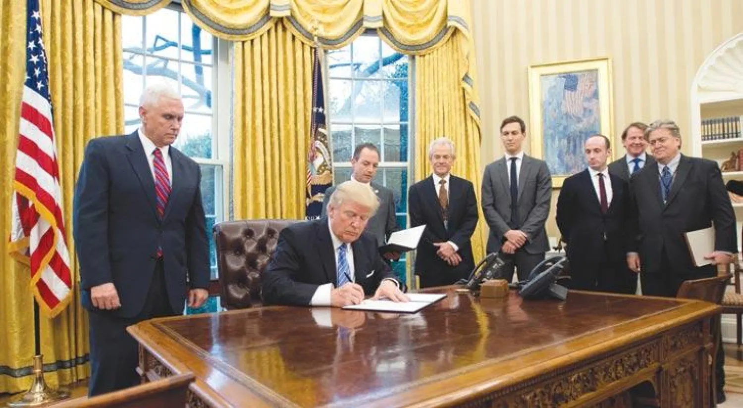 ترمب يوقع أول قرار تنفيذي له في البيت الأبيض أمس (إ.ب.أ)