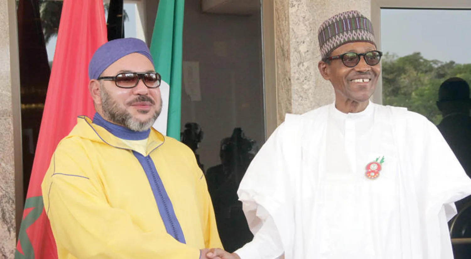 العاهل المغربي مصافحا الرئيس النيجيري محمد بخاري خلال زيارته الأخيرة لنيجيريا في ديسمبر الماضي (أ.ف.ب)