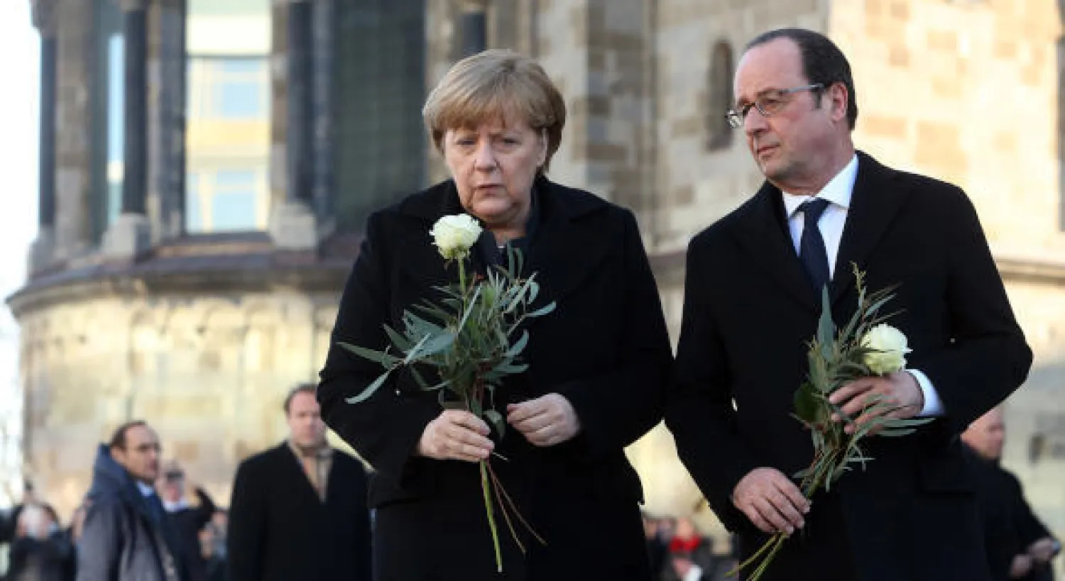 أنجيلا ميركل المستشارة الألمانية وفرانسوا هولاند الرئيس الفرنسي، يضعان الزهور على نصب تذكاري لضحايا الهجوم على سوق عيد الميلاد في برلين (إ.ف.ب)