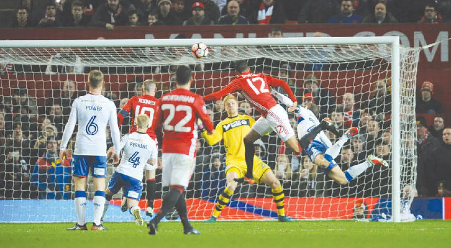 سمولينغ مدافع يونايتد(رقم 12) يقفز عاليا ليسجل برأسه في مرمى ويغان (اب)