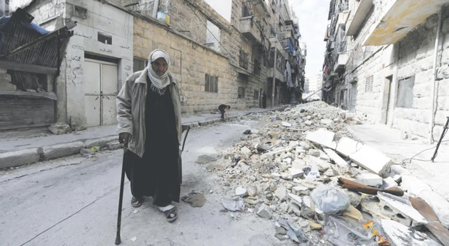 سوري بين الخراب في زقاق بمدينة حلب أمس (رويترز)