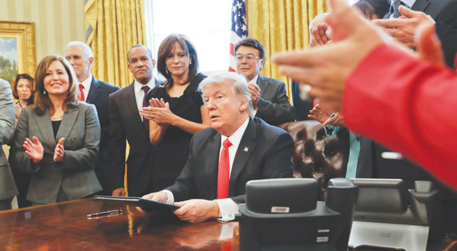ترمب بعد توقيعه على قرار يدعو لتقليص اللوائح التنظيمية لدى المؤسسات الصغيرة في المكتب البيضاوي أمس (أ.ب)