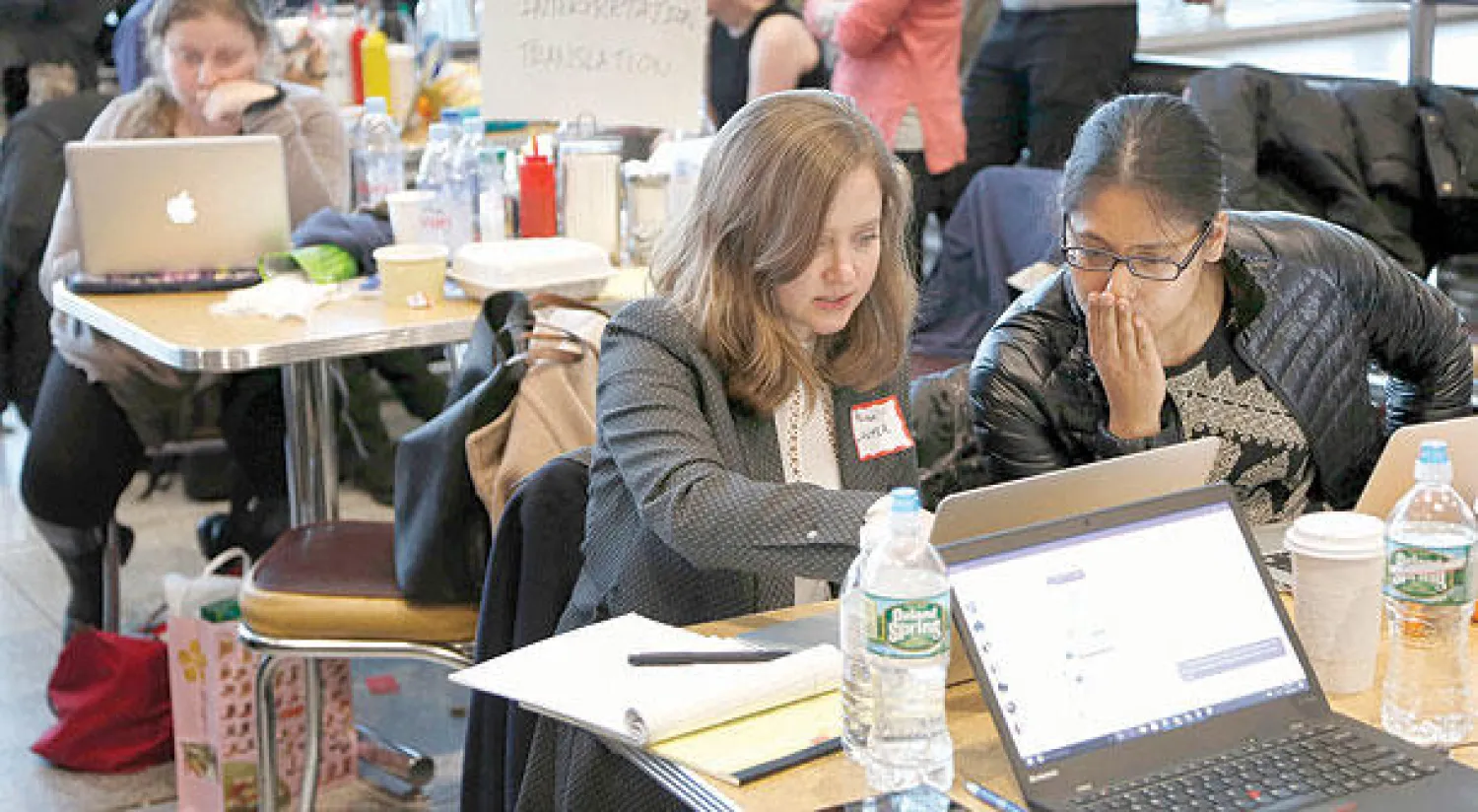 محاميات متطوعات يساعدن مسافرين جرى توقيفهم في مطار جون كيندي بنيويورك تنفيذًا لقرار ترمب حول الهجرة (أ.ب)