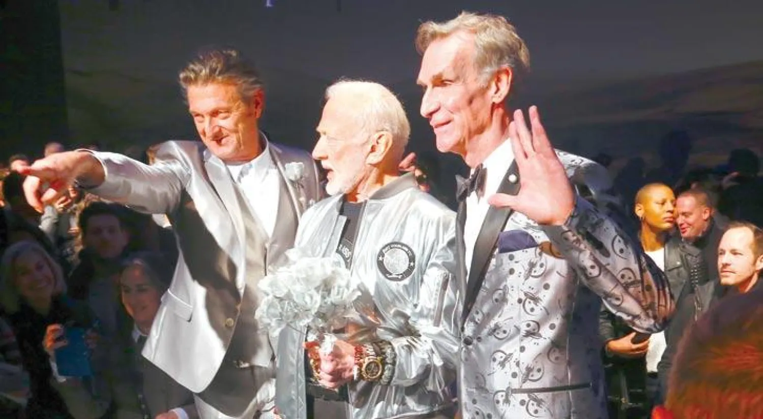 مصمم الأزياء نيك غراهام (إلى اليسار) مع رائد الفضاء باز ألدرين في الوسط ثم بيل ناي الممثل في الفيلم التلفزيزني «رجل العلم» أثناء عرض الأزياء في نيويورك (أ.ب)