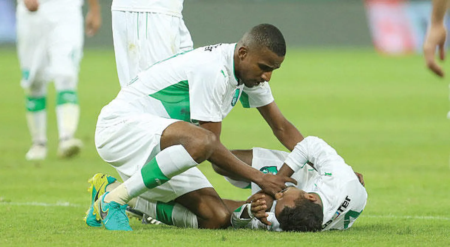 بلغيث يطمئن على زميله عواجي بعد الإصابة التي تعرض لها (تصوير: محمد المانع)