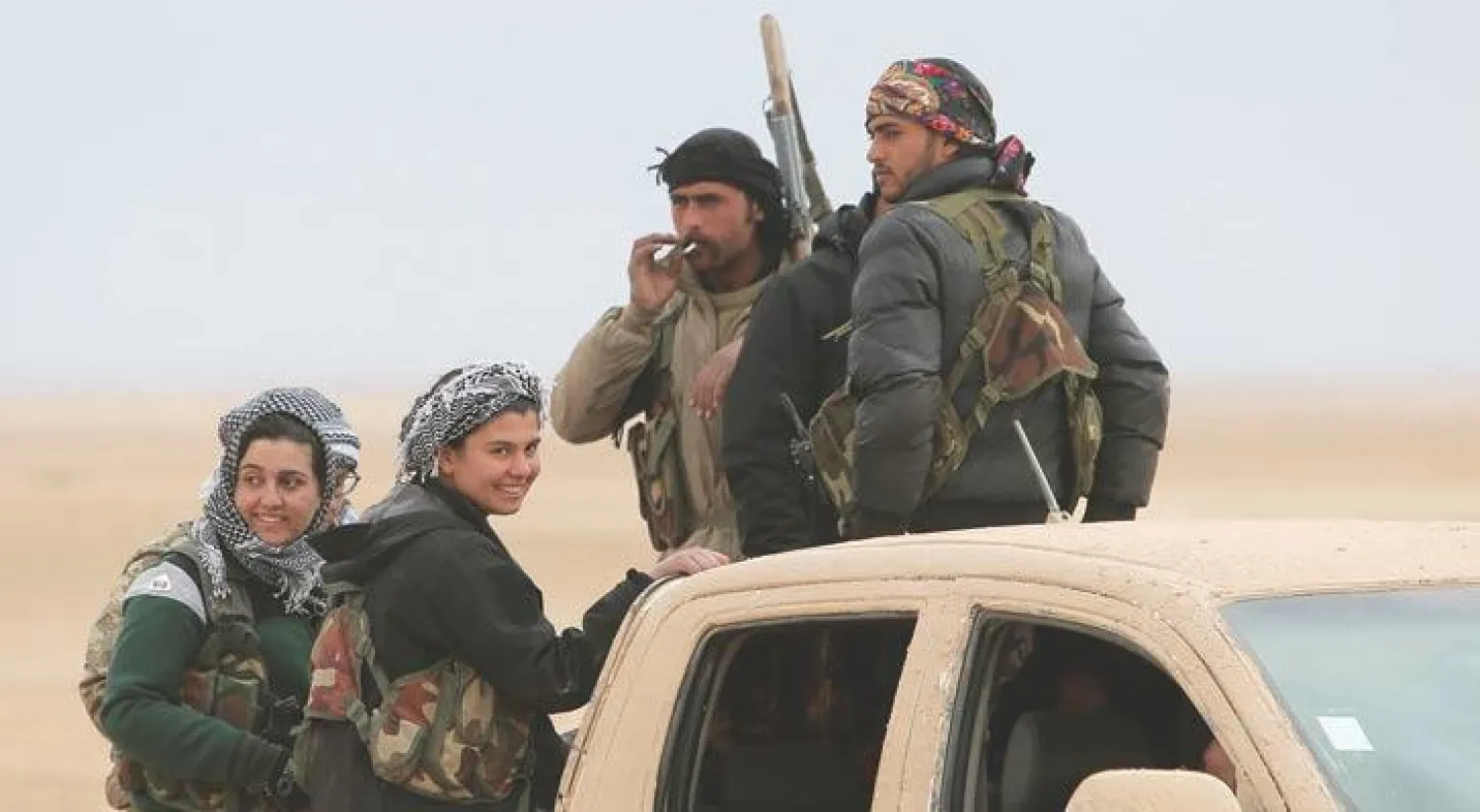 مقاتلون من «سوريا الديمقراطية»، أمس، فوق عربة عسكرية شمال الرقة التي يسيطر عليها تنظيم داعش (رويترز)