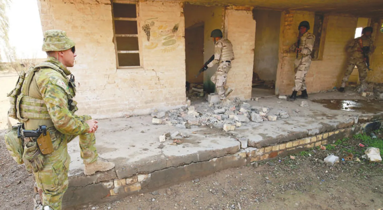 عناصر في شرطة نينوى خلال تمرين تحت إشراف مدربين أستراليين في معسكر التاجي شمال بغداد أمس (رويترز)