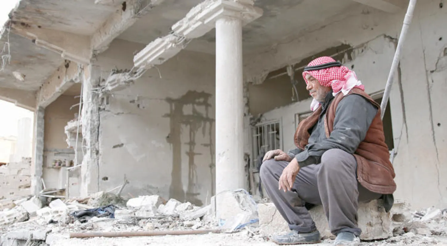 رجل من قرية اليادودة بريف درعا يراقب الدمار الذي لحق بمنزله أول من أمس بعد غارات لطيران النظام على مناطق تسيطر عليها فصائل معارضة (رويترز)