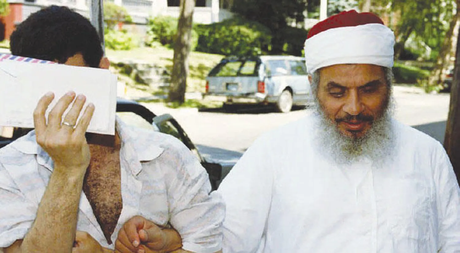 عمر عبد الرحمن بعد صلاة الجمعة في نيوجيرسي الأميركية بصحبة أحد مرافقيه في يونيو 1993 (أ.ف.ب)